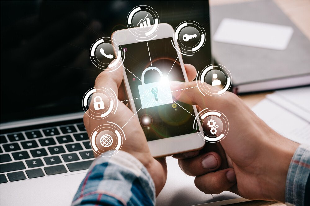 Person holding smartphone with glowing lock icon and cybersecurity symbols representing SQL Server Change Data Capture security, data encryption, access control and real-time data protection
